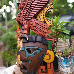 Peut inclure: Un masque en bois color&eacute; avec un motif de jaguar et d'aigle. Le masque est peint dans des tons de rouge, orange, jaune, vert, bleu et marron. Le masque est sculpt&eacute; avec des d&eacute;tails complexes et est un bel exemple d'art populaire mexicain.