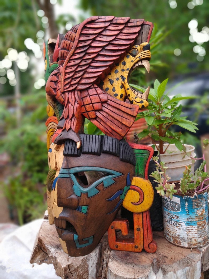Peut inclure: Un masque en bois color&eacute; avec un motif de jaguar et d'aigle. Le masque est peint dans des tons de rouge, orange, jaune, vert, bleu et marron. Le masque est sculpt&eacute; avec des d&eacute;tails complexes et est un bel exemple d'art populaire mexicain.