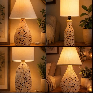 May include: A table lamp featuring a beige fabric lampshade and a textured ceramic base with intricate carved patterns of parrots and sunflowers. The lamp emits a warm glow, highlighting the detailed relief work on the off-white ceramic surface.