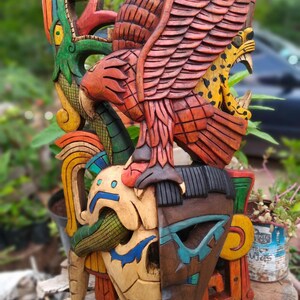 Peut inclure: Un masque en bois color&eacute; avec un visage de cr&acirc;ne, un jaguar et un oiseau aux ailes d&eacute;ploy&eacute;es. Le masque est peint dans des tons de rouge, vert, bleu, jaune et marron.