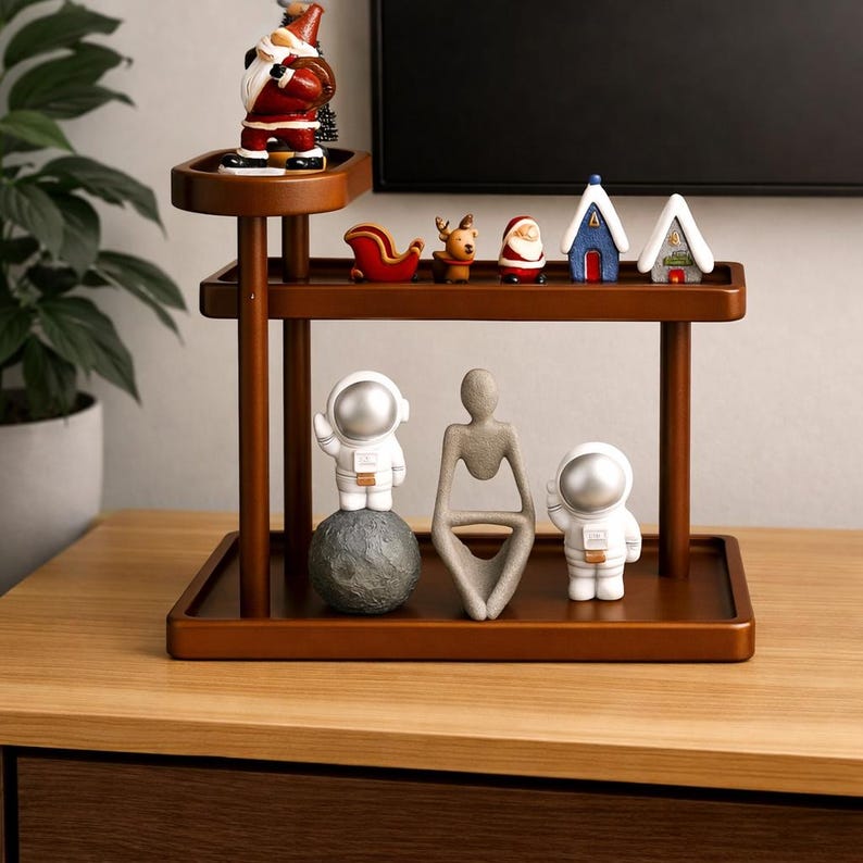 May include: A wooden decorative shelf unit with multiple tiers, showcasing various ornaments. The top shelf features a Santa Claus figure and festive decorations. The lower shelves display astronaut figurines and abstract sculptures.
