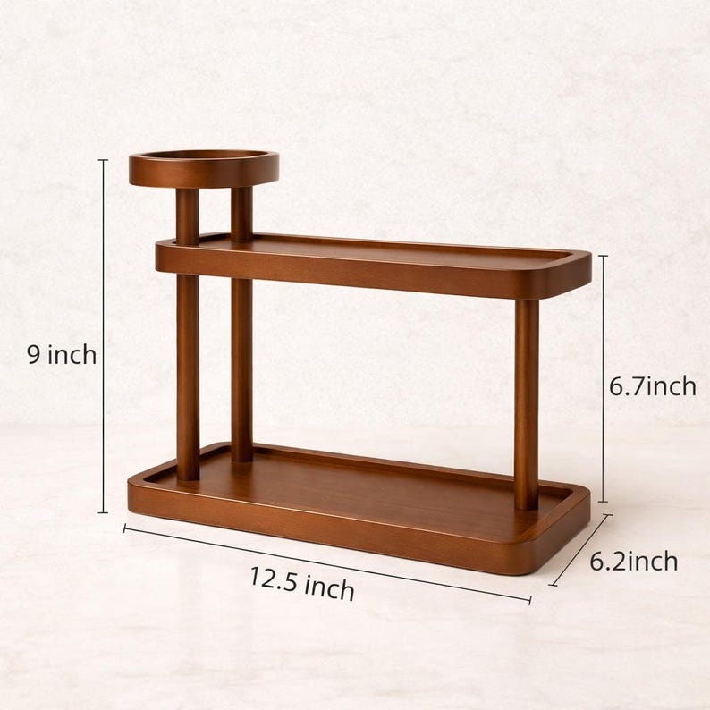 May include: A brown wooden decorative shelf with a tiered design. The shelf measures 31.75 cm long, 22.86 cm high, and 15.75 cm wide. It features a small circular top shelf and two rectangular shelves.
