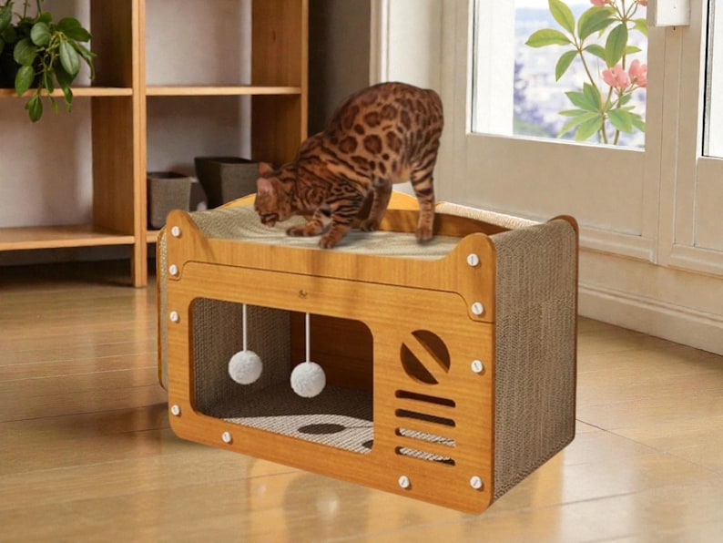 May include: A wooden cat house with a scratching surface on top and a playful design. The cat house has a rectangular shape with a brown finish, a cut-out window, and two hanging pom-poms. A brown and tan spotted cat is standing on top.