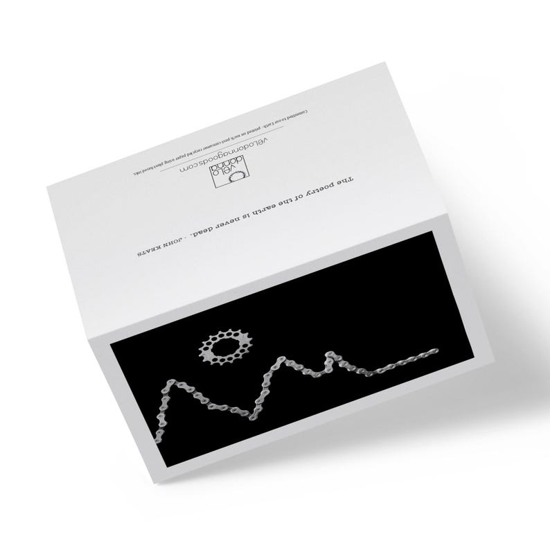 Op de afbeelding: Een zwart-witte afbeelding van een fietsketting die een bergketen vormt met een fietskettingwiel als zon.