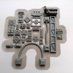 May include: A sheet of grey plastic with various shapes and sizes of 3D printed parts. The parts are designed to look like futuristic or sci-fi building elements.