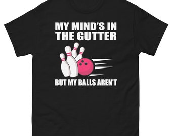May include: Black t-shirt with white text that reads "My mind's in the gutter but my balls aren't". The text is accompanied by a graphic of bowling pins and a bowling ball.