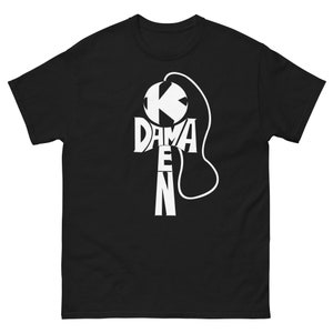 May include: Black t-shirt featuring a white graphic of a kendama, a traditional Japanese toy. The graphic is formed from the letters "K", "DAMA", "KEN", and "N".