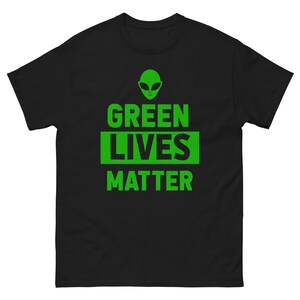 May include: Black t-shirt with a green alien graphic and the text "GREEN LIVES MATTER" in green.