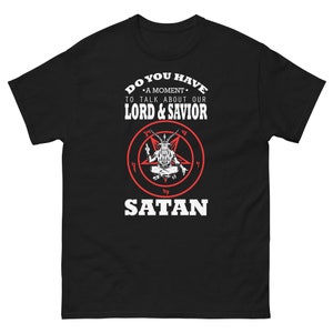 Puede incluir: Camiseta negra con texto blanco que dice "¿Tienes un momento para hablar de nuestro Señor y Salvador Satanás?" Un pentagrama rojo con un diablo blanco en su interior está centrado en la camiseta.