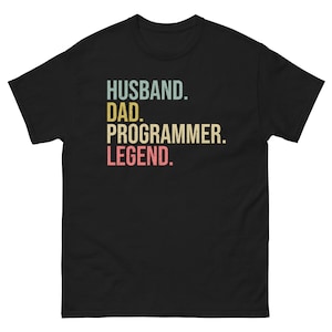 Op de afbeelding: Zwart T-shirt met een vintage-stijl grafische afbeelding met de tekst "Husband. Dad. Programmer. Legend."