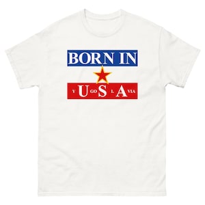 May include: White t-shirt with the text "BORN IN" in blue letters above a red rectangle with a yellow star and the text "YUGO" in blue letters and "SLAVIA" in blue letters.