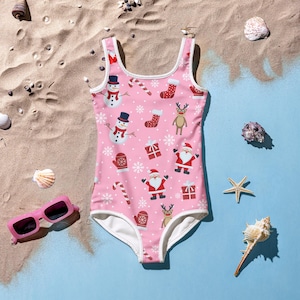 May include: Pink swimsuit with a Christmas theme featuring Santa Claus, snowmen, reindeer, candy canes, and snowflakes.