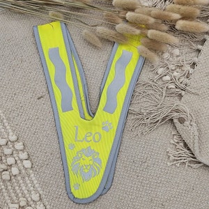 May include: Yellow safety vest with reflective strips and a lion graphic. The vest has the name "Leo" printed on it.