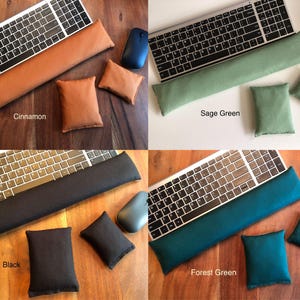 May include: Four sets of computer accessories: a keyboard, a wrist rest, a mouse, and two small pillows. The sets are in cinnamon, sage green, black, and forest green. The cinnamon set is on a wooden surface, the sage green set is on a white surface, and the black and forest green sets are on a wooden surface.