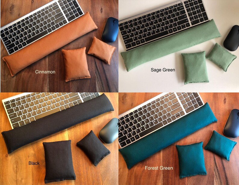 May include: Four sets of computer accessories: a keyboard, a wrist rest, a mouse, and two small pillows. The sets are in cinnamon, sage green, black, and forest green. The cinnamon set is on a wooden surface, the sage green set is on a white surface, and the black and forest green sets are on a wooden surface.