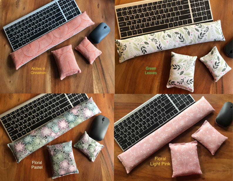 May include: Four sets of keyboard wrist rests and matching small pillows in various patterns and colors. The sets include a keyboard, a wrist rest, a mouse, and two small pillows. The patterns include arches in cinnamon, green leaves, floral pastel, and floral light pink.