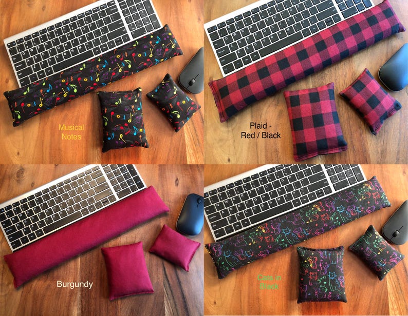 May include: Four keyboard wrist rests and matching small pillows in various designs. One features musical notes, another a red and black plaid pattern, a third is burgundy, and the last has a cat design. Each set includes a keyboard and mouse.
