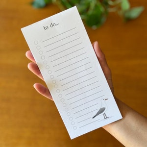 May include: A white to-do list notepad with a black and grey seagull illustration at the bottom. The notepad has a black header that says "to do..." and 25 blank lines with circles for checking off tasks.