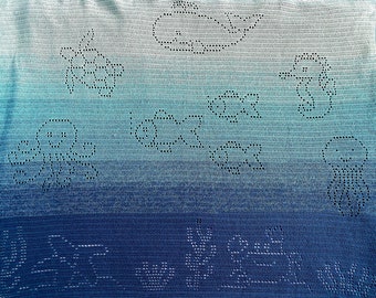May include: A blue and white ombre crochet blanket with a variety of crocheted designs, including flowers, clouds, and a house.