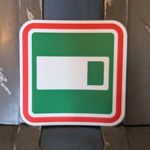 May include: A green square with a white rectangle and a smaller green rectangle inside. The square has a red border.