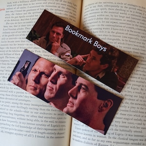 May include: Three bookmark designs featuring close-up photos of actors Kyle MacLachlan and  Ray Wise from the television series "Twin Peaks". The bookmarks are printed on a brown background with the text "Bookmark Boys" in white.