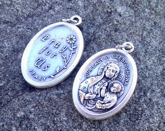 May include: Two silver oval pendants. One features a depiction of the Virgin Mary holding a baby Jesus with the text "Our Lady of Czestochowa". The other pendant has the text "Pray for Us Italy" with a floral design.