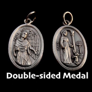 Puede incluir: Medalla de doble cara de color plateado con un lazo para colgar. Un lado presenta una figura con el texto "PADRE KOLBE" y el otro lado muestra una figura con el texto "ITALY". El texto "Double-sided Medal" está en la parte inferior.