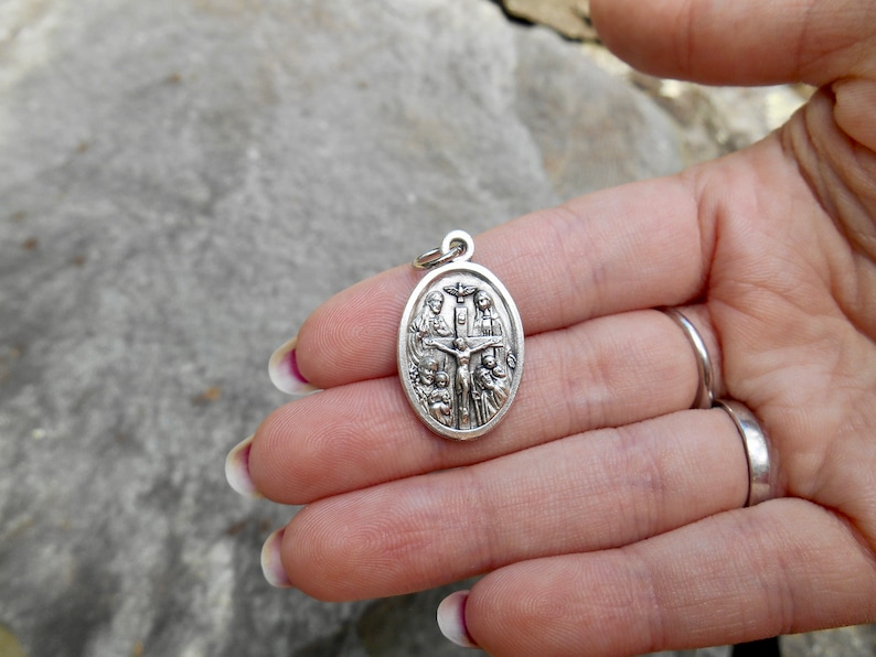 Pu&ograve; includere: Pendente ovale in argento con una rappresentazione di Ges&ugrave; sulla croce circondato da figure.