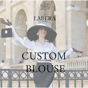 May include: A woman wearing a white blouse with a black belt, a black hat, and black gloves. The text "CUSTOM BLOUSE" is written in black letters on a white background.