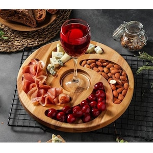 以下が含まれることがあります： スナック用の仕切りが4つある木製サービングトレイ。トレイにはワイングラスホルダーが内蔵されており、チーズ、肉、チェリー、アーモンドが詰められています。