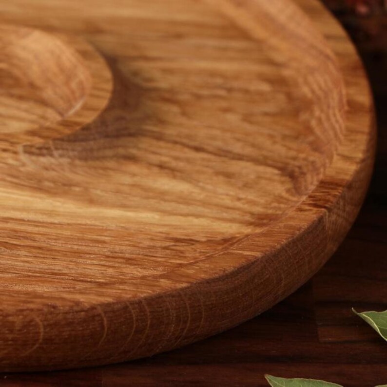 May include: A round wooden serving tray with a raised edge and a smooth, natural wood finish.