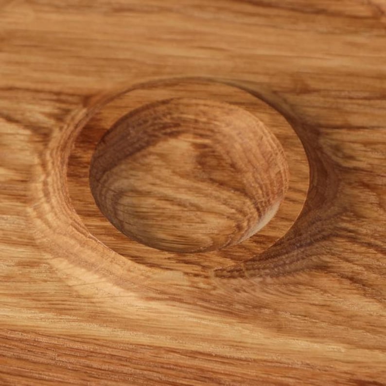May include: Close-up of a wooden serving tray with a circular indentation. The tray is made of light brown wood with a natural grain pattern.