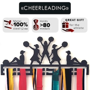 Puede incluir: Soporte de medallas de metal negro con un diseño de silueta de animadora. El soporte muestra el texto "MEDAL HOLDER" y "CHEERLEADING". Está hecho de acero 100% y puede contener más de 80 medallas. Cintas de colores cuelgan debajo.