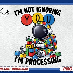 May include: A colorful illustration features an astronaut in a puzzle-piece design, building blocks. Text reads "I'M NOT IGNORING YOU I'M PROCESSING." The design includes red, yellow, and blue accents, with a "PNG" logo.