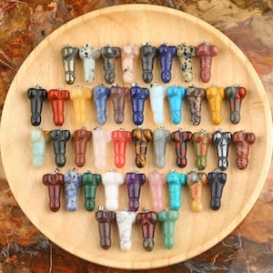 Könnte beinhalten: Eine Sammlung von 36 bunten Edelstein-Anhängern in verschiedenen Formen und Größen. Die Anhänger sind auf einem Holzteller ausgestellt.