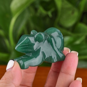 May include: A green jade stone carved into the shape of a mouse. The mouse is sitting on its hind legs with its front paws outstretched.