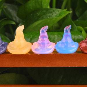 May include: Five small, colourful, crystal witch hats. The hats are made of amethyst, citrine, opal, blue lace agate, and red jasper.