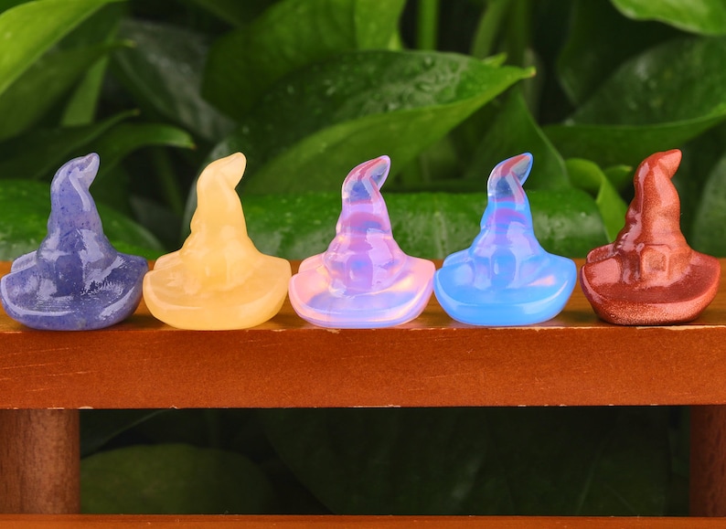 May include: Five small, colourful, crystal witch hats. The hats are made of amethyst, citrine, opal, blue lace agate, and red jasper.