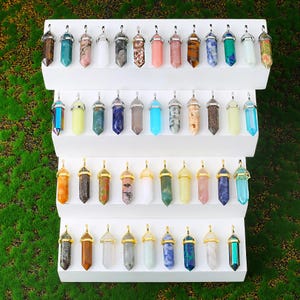 Natural double terminated crystal pendant featuring a hexagonal prism gemstone point with polished finish and metal cap. making it lightweight and comfortable for everyday wear. Available in multiple gemstone styles and colors. The top metal bail in gold or silver tone allows easy attachment to chains, cords, or jewelry findings. This double point crystal pendant is ideal for necklace making, DIY jewelry design, chakra jewelry, energy crystal accessories, and handmade craft projects.
