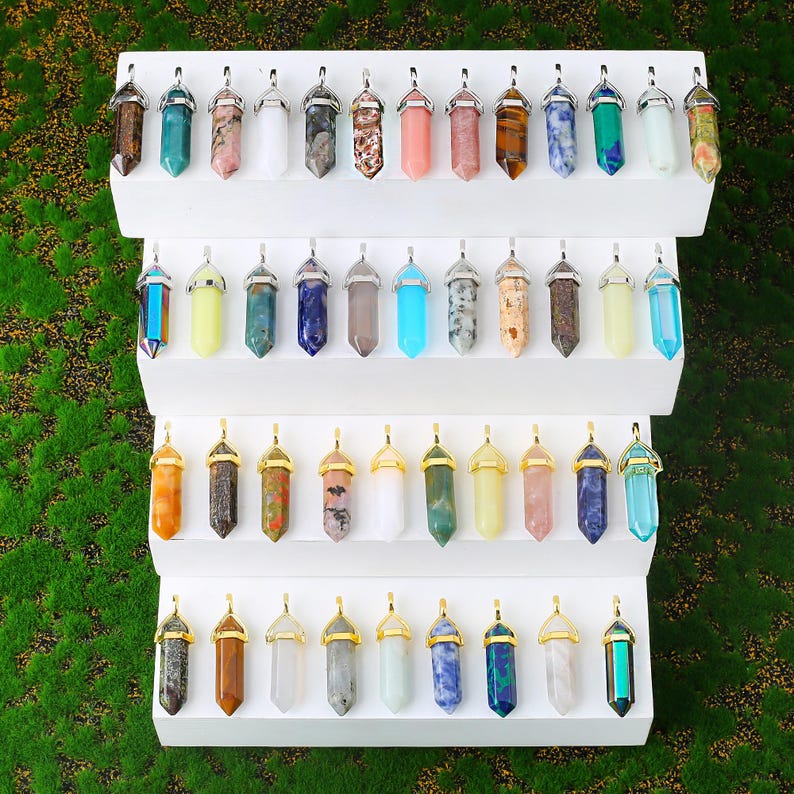 Natural double terminated crystal pendant featuring a hexagonal prism gemstone point with polished finish and metal cap. making it lightweight and comfortable for everyday wear. Available in multiple gemstone styles and colors. The top metal bail in gold or silver tone allows easy attachment to chains, cords, or jewelry findings. This double point crystal pendant is ideal for necklace making, DIY jewelry design, chakra jewelry, energy crystal accessories, and handmade craft projects.