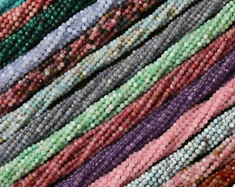 May include: Assortment of gemstone beads in various colors, including green, blue, pink, purple, and brown. The beads are strung together in long strands and are arranged in a diagonal pattern.