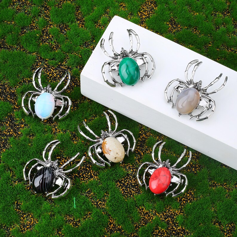 Handcrafted natural crystal spider featuring a polished gemstone body set in a finely crafted alloy spider frame. designed with natural stones creating a luxurious and artistic jewelry piece. The smooth gemstone surface and detailed spider legs give it a striking and elegant appearance. Perfect as a pendant necklace or brooch accessory symbolizing creativity, protection, and good fortune. Ideal for meditation energy healing, spiritual balance, fashion styling, gift giving, and decorative display