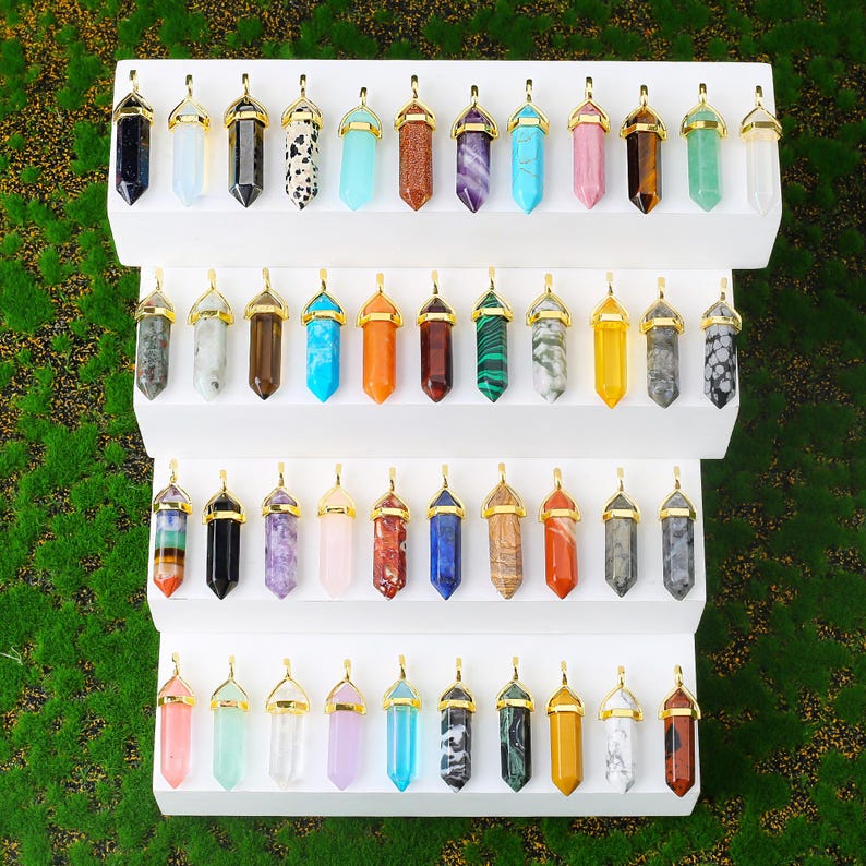 Natural double terminated crystal pendant featuring a hexagonal prism gemstone point with polished finish and metal cap. making it lightweight and comfortable for everyday wear. Available in multiple gemstone styles and colors. The top metal bail in gold or silver tone allows easy attachment to chains, cords, or jewelry findings. This double point crystal pendant is ideal for necklace making, DIY jewelry design, chakra jewelry, energy crystal accessories, and handmade craft projects.