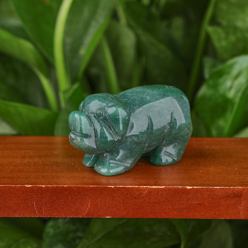 May include: A green jade pig figurine. The pig is standing on all four legs and has a detailed face.