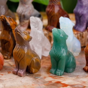 Puede incluir: Una colecci&oacute;n de figuritas de animales talladas en piedras preciosas. Las figuritas son de varios colores, incluyendo verde, marr&oacute;n, blanco y morado. Las figuritas tienen todas la forma de lobos o perros, con la cabeza inclinada hacia arriba.
