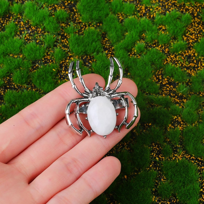 Handcrafted natural crystal spider featuring a polished gemstone body set in a finely crafted alloy spider frame. designed with natural stones creating a luxurious and artistic jewelry piece. The smooth gemstone surface and detailed spider legs give it a striking and elegant appearance. Perfect as a pendant necklace or brooch accessory symbolizing creativity, protection, and good fortune. Ideal for meditation energy healing, spiritual balance, fashion styling, gift giving, and decorative display