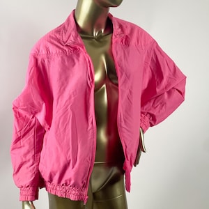 May include: A pink nylon jacket with a zipper closure and a drawstring waist.