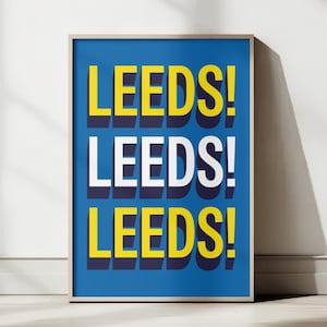 Puede incluir: Un póster enmarcado con la palabra "LEEDS!" repetida tres veces en una fuente audaz y en capas. Las instancias superior e inferior son amarillas con una sombra azul oscuro, mientras que la del medio es blanca. El fondo es azul liso.