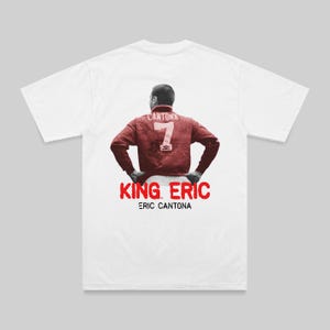Puede incluir: Camiseta blanca con una imagen roja y blanca de un jugador de fútbol que lleva una camiseta con el número 7 y el texto "KING. ERIC ERIC CANTONA".