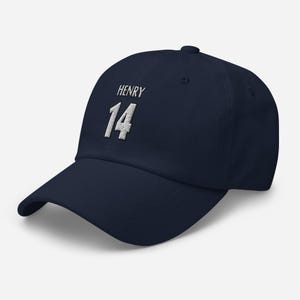 May include: A navy blue baseball cap with white embroidered text that reads "HENRY 14".